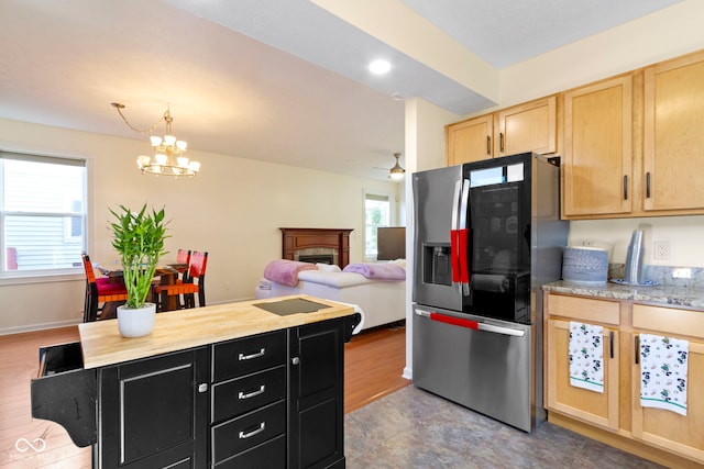 2454 N Talbott St, Indianapolis, IN 46205 - kitchen featuring stainless steel fridge, dark cabinets, light brown cabinetry, a fireplace, and decorative light fixtures