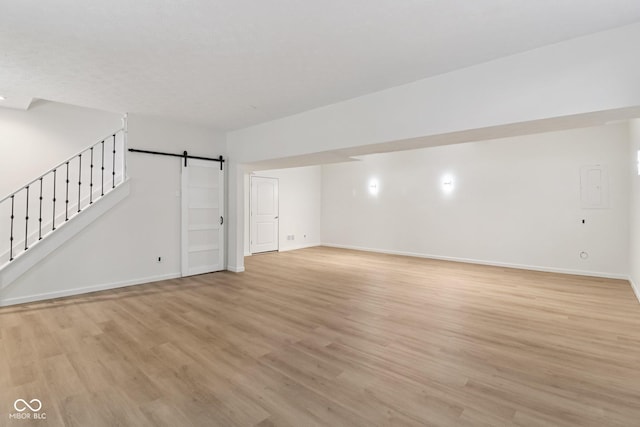 11845 Discovery Cir, Indianapolis, IN 46236 - unfurnished living room featuring a barn door, light wood-style floors, and stairs