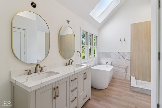 11845 Discovery Cir, Indianapolis, IN 46236 - bathroom with a skylight, tile walls, a freestanding tub, double vanity, and a wainscoted wall