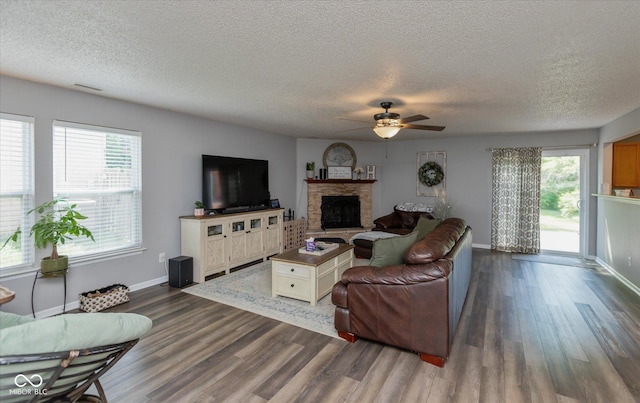 7950 Crackling Ln, Indianapolis, IN 46259 - living room featuring ceiling fan, dark wood finished floors, a textured ceiling, and a stone fireplace