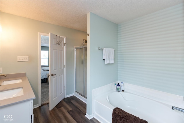 7950 Crackling Ln, Indianapolis, IN 46259 - bathroom with a garden tub, wood finished floors, a stall shower, a textured ceiling, and double vanity