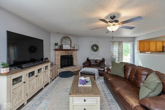 7950 Crackling Ln, Indianapolis, IN 46259 - living room featuring a textured ceiling, a ceiling fan, and a stone fireplace