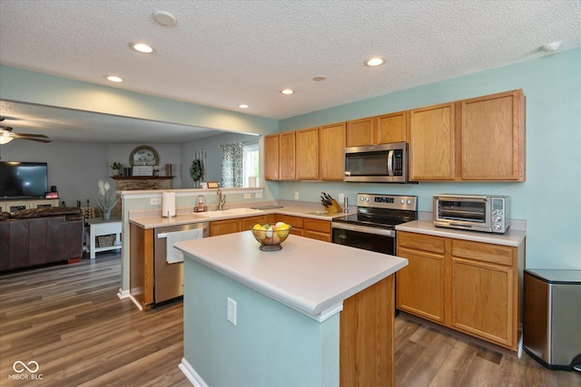 7950 Crackling Ln, Indianapolis, IN 46259 - kitchen with appliances with stainless steel finishes, a peninsula, open floor plan, a textured ceiling, and light countertops