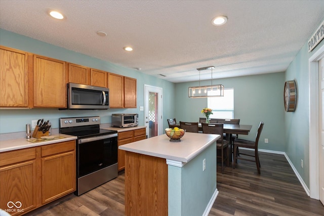 7950 Crackling Ln, Indianapolis, IN 46259 - kitchen with appliances with stainless steel finishes, dark wood finished floors, light countertops, pendant lighting, and a center island