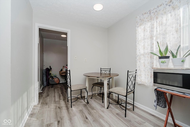 2466 Sickle Rd, Indianapolis, IN 46219 - dining room with light wood finished floors and a textured ceiling