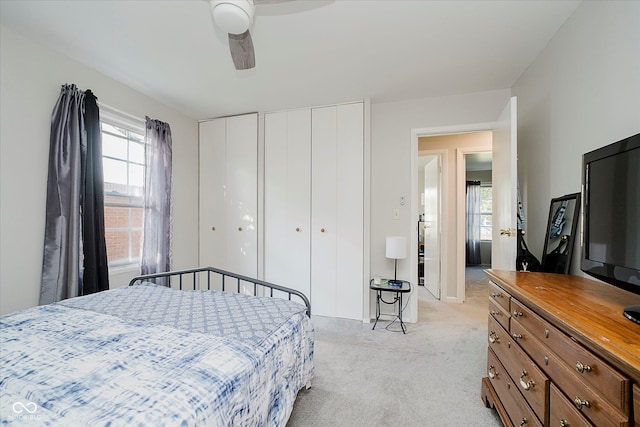 2466 Sickle Rd, Indianapolis, IN 46219 - bedroom featuring two closets, light colored carpet, and a ceiling fan