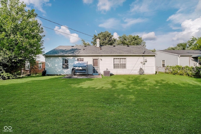 2466 Sickle Rd, Indianapolis, IN 46219 - rear view of house featuring a lawn, a patio area, and a chimney