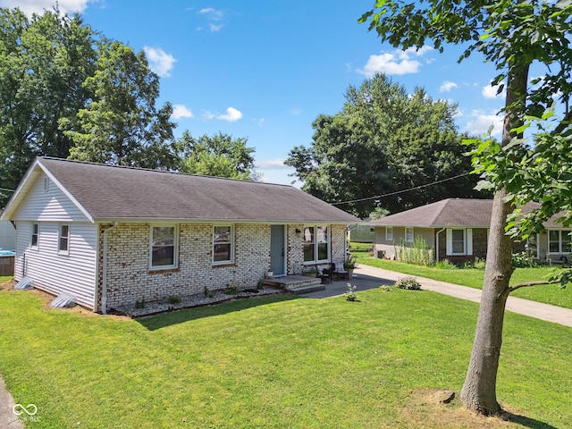 1743 Chandler Ln, Columbus, IN 47203 - ranch-style home featuring brick siding, a front lawn, concrete driveway, and a shingled roof