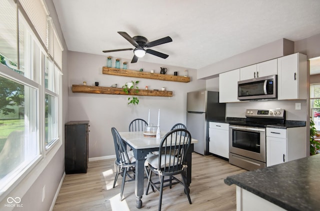 1743 Chandler Ln, Columbus, IN 47203 - kitchen featuring appliances with stainless steel finishes, white cabinets, light wood-type flooring, dark countertops, and a ceiling fan