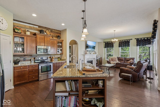 1387 Mayfield Ct, Westfield, IN 46074 - kitchen with stainless steel appliances, brown cabinetry, open shelves, open floor plan, and dark wood-style floors