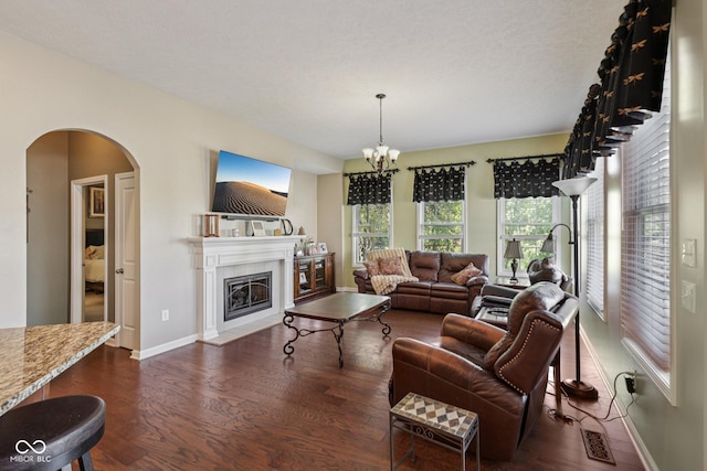 1387 Mayfield Ct, Westfield, IN 46074 - living area with dark wood-type flooring, arched walkways, a chandelier, and a fireplace with flush hearth