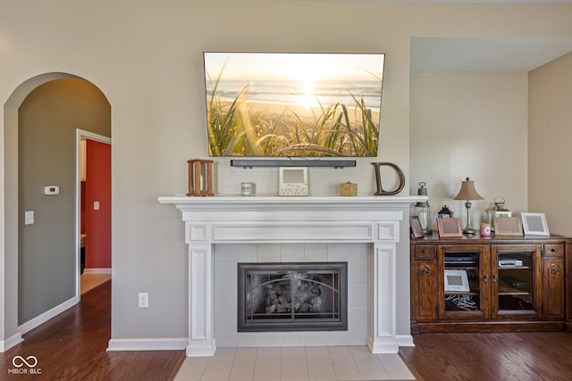 1387 Mayfield Ct, Westfield, IN 46074 - living area with wood finished floors, arched walkways, and a tiled fireplace