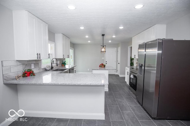 7950 N 475 E, Columbus, IN 47203 - kitchen featuring appliances with stainless steel finishes, a peninsula, white cabinetry, recessed lighting, and light stone countertops