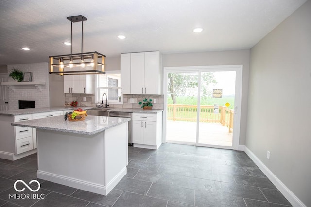 7950 N 475 E, Columbus, IN 47203 - kitchen featuring stainless steel dishwasher, tasteful backsplash, white cabinets, a peninsula, and light stone countertops