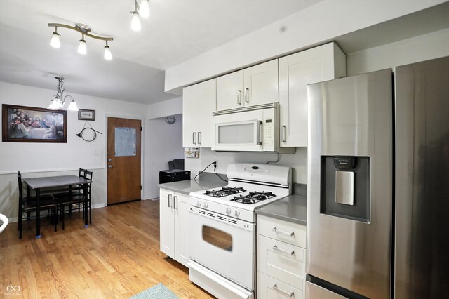 5560 Royal Oak Ct, Indianapolis, IN 46227 - kitchen with white appliances, a chandelier, white cabinets, light wood-style flooring, and light countertops