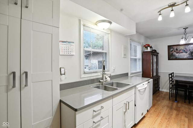 5560 Royal Oak Ct, Indianapolis, IN 46227 - kitchen featuring white dishwasher, white cabinets, light wood finished floors, and decorative light fixtures