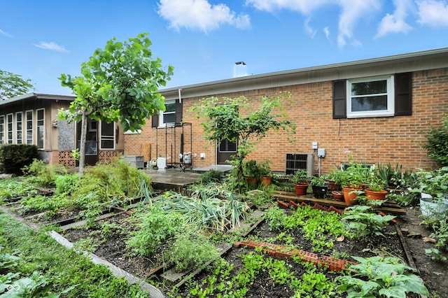 5560 Royal Oak Ct, Indianapolis, IN 46227 - rear view of house featuring brick siding and a vegetable garden