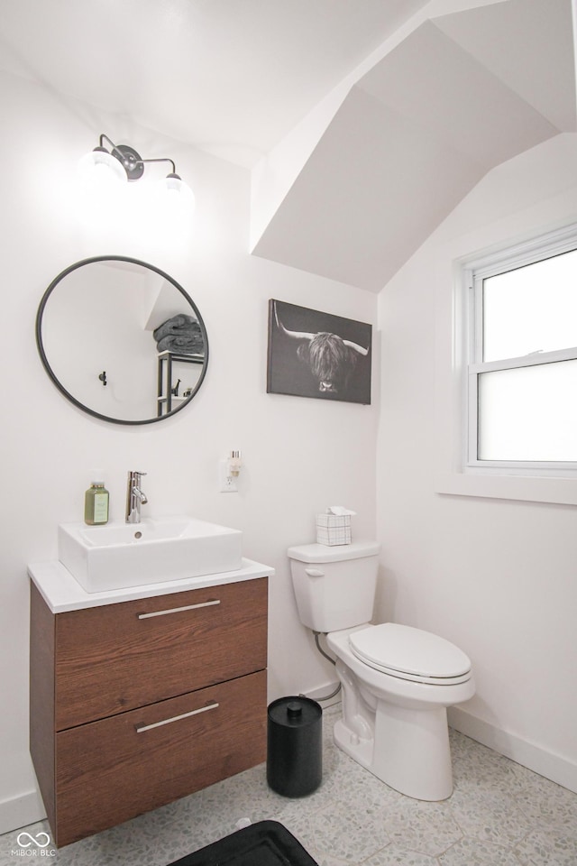 1606 California St, Columbus, IN 47201 - bathroom featuring vanity, vaulted ceiling, and speckle patterned floor