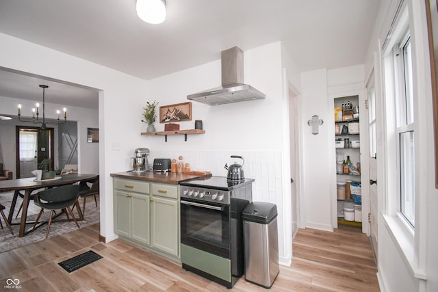 1606 California St, Columbus, IN 47201 - kitchen featuring wall chimney range hood, stainless steel electric range, light wood-type flooring, and green cabinets
