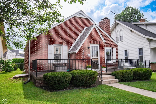 1606 California St, Columbus, IN 47201 - view of front of house featuring brick siding, a front yard, a chimney, and roof with shingles