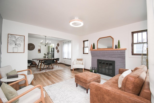 1606 California St, Columbus, IN 47201 - living area with light wood-type flooring, a chandelier, and a brick fireplace