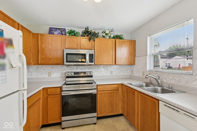 7930 Cork Bend Ln, Indianapolis, IN 46239 - kitchen featuring stainless steel appliances, light countertops, decorative backsplash, light tile patterned floors, and brown cabinets