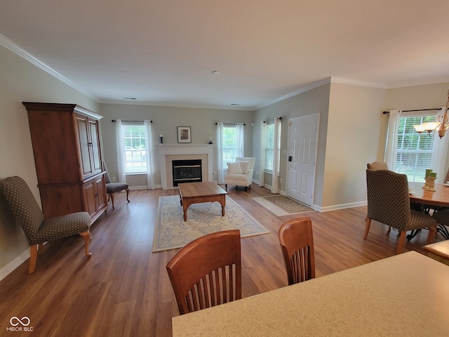 1096 Shadow Ridge Rd, Carmel, IN 46280 - living area featuring wood finished floors, a chandelier, a fireplace with flush hearth, and ornamental molding