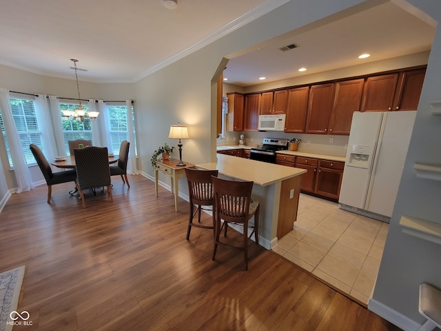1096 Shadow Ridge Rd, Carmel, IN 46280 - kitchen with white appliances, crown molding, light countertops, light wood-style flooring, and decorative light fixtures