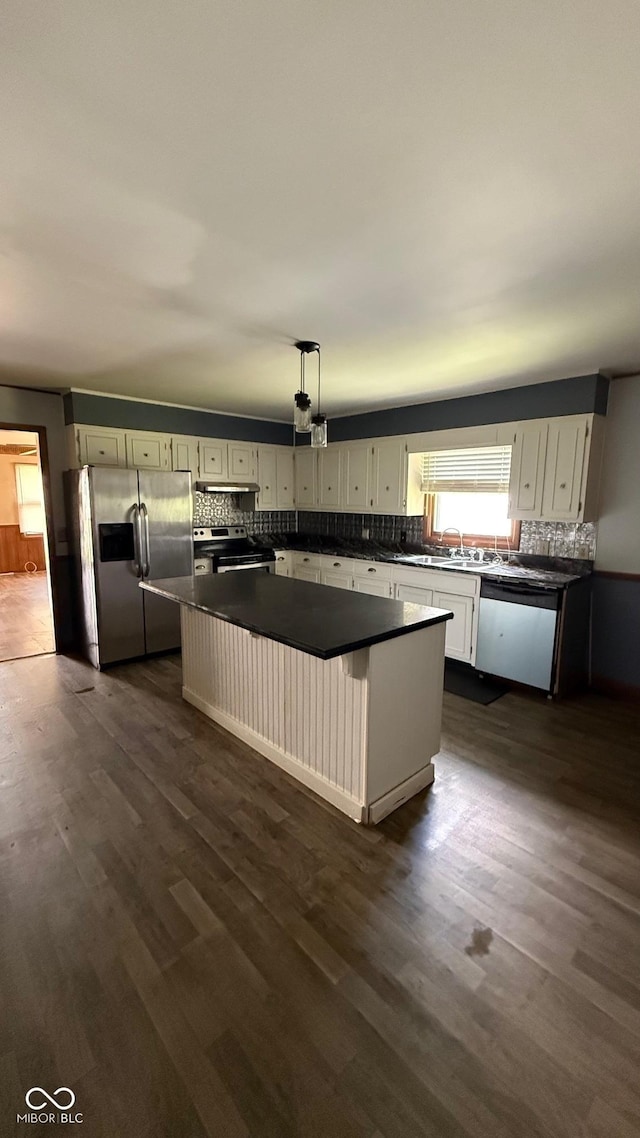 9 E Reel Ave, Vincennes, IN 47591 - kitchen featuring appliances with stainless steel finishes, dark countertops, a kitchen island, and tasteful backsplash