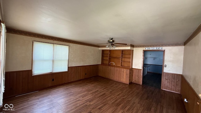 9 E Reel Ave, Vincennes, IN 47591 - empty room featuring wainscoting, dark wood finished floors, wood walls, and ceiling fan