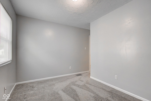3426 N Olney St, Indianapolis, IN 46218 - spare room featuring healthy amount of natural light, carpet, and a textured ceiling