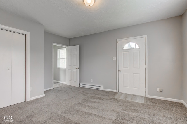 3426 N Olney St, Indianapolis, IN 46218 - entrance foyer featuring a baseboard radiator, carpet floors, and a textured ceiling