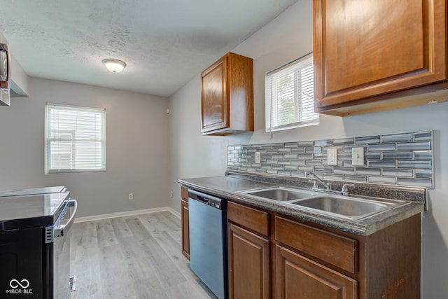 3426 N Olney St, Indianapolis, IN 46218 - kitchen with dishwashing machine, dark countertops, light wood finished floors, plenty of natural light, and a textured ceiling