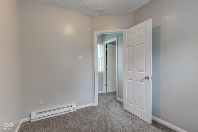 3426 N Olney St, Indianapolis, IN 46218 - carpeted empty room featuring a baseboard heating unit and a textured ceiling