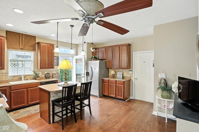 13534 E 131st St, Fishers, IN 46037 - kitchen with refrigerator with ice dispenser, a ceiling fan, tasteful backsplash, light wood-style flooring, and a kitchen breakfast bar