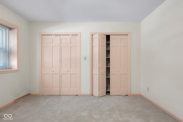 3905 Cove Rd, Columbus, IN 47203 - unfurnished bedroom featuring two closets, carpet floors, and a baseboard heating unit