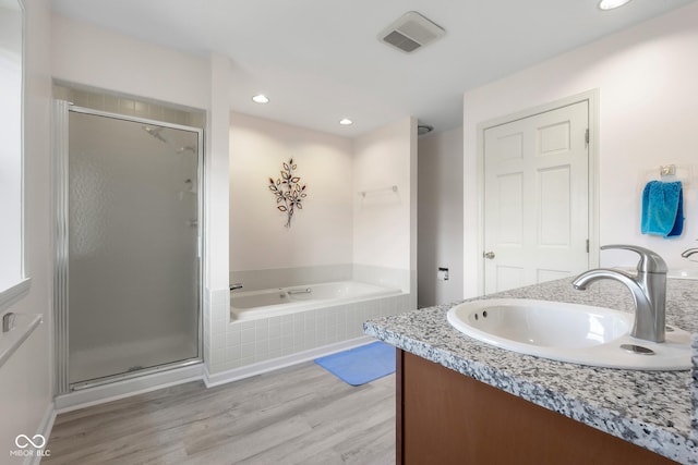 3905 Cove Rd, Columbus, IN 47203 - bathroom with a garden tub, a stall shower, vanity, wood finished floors, and recessed lighting