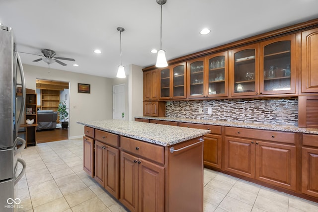 3905 Cove Rd, Columbus, IN 47203 - kitchen featuring light tile patterned floors, freestanding refrigerator, backsplash, ceiling fan, and hanging light fixtures