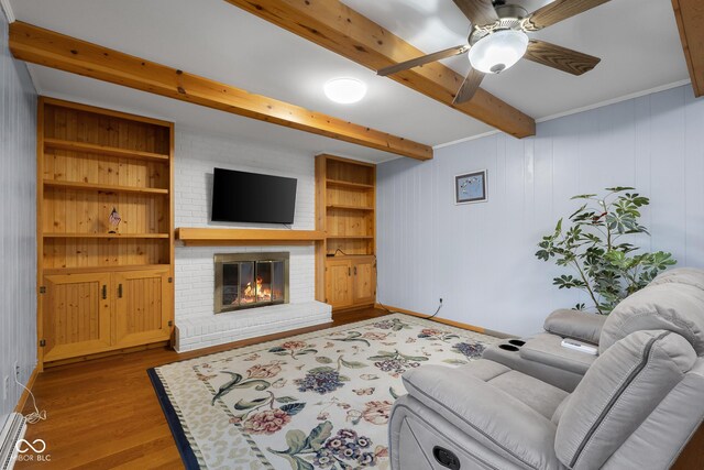 3905 Cove Rd, Columbus, IN 47203 - living area featuring beam ceiling, a fireplace, wood finished floors, ceiling fan, and a baseboard heating unit