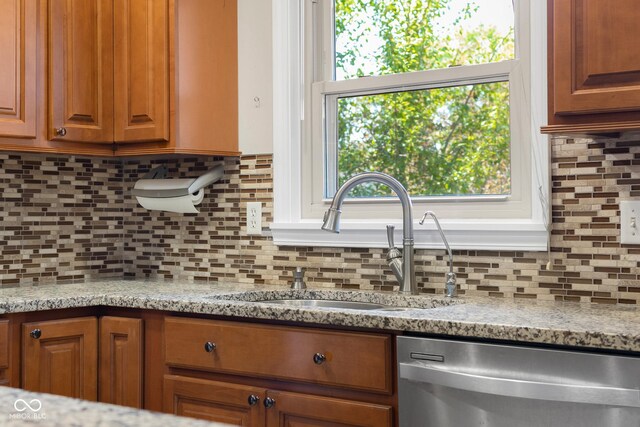 3905 Cove Rd, Columbus, IN 47203 - kitchen with stainless steel dishwasher, backsplash, and brown cabinetry