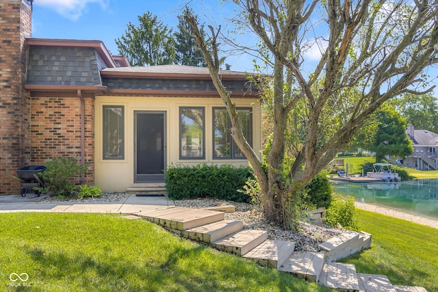 3905 Cove Rd, Columbus, IN 47203 - property entrance with roof with shingles, a yard, mansard roof, brick siding, and a chimney