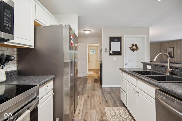 897 Wildwood Rd, North Vernon, IN 47265 - kitchen featuring stainless steel appliances, dark countertops, white cabinets, tasteful backsplash, and dark wood-type flooring