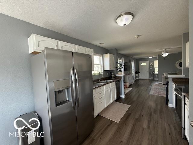 5714 High Timber Ln, Indianapolis, IN 46235 - kitchen featuring stainless steel appliances, white cabinetry, dark wood-style floors, dark countertops, and a ceiling fan