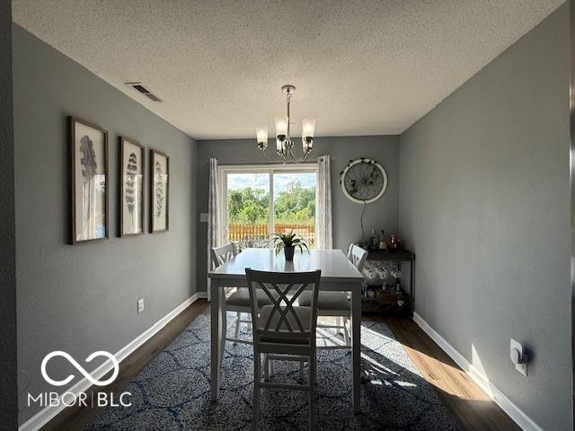 5714 High Timber Ln, Indianapolis, IN 46235 - dining area featuring dark wood-style flooring, a chandelier, and a textured ceiling