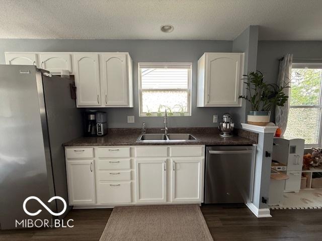 5714 High Timber Ln, Indianapolis, IN 46235 - kitchen featuring stainless steel appliances, dark wood-style flooring, a textured ceiling, dark countertops, and white cabinets