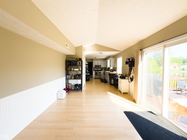 8017 Cardinal Cv W, Indianapolis, IN 46256 - corridor with lofted ceiling, light wood-style flooring, and a wainscoted wall