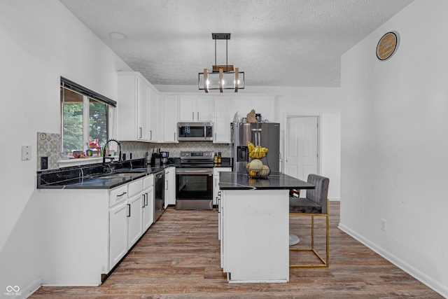 10249 Winlee Ct, Indianapolis, IN 46236 - kitchen featuring stainless steel appliances, dark countertops, a breakfast bar, a textured ceiling, and backsplash