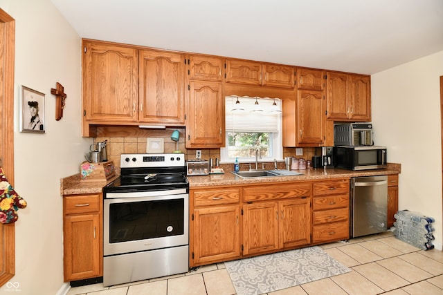 4020 S Lynhurst Dr, Indianapolis, IN 46221 - kitchen with appliances with stainless steel finishes, backsplash, light tile patterned flooring, and brown cabinetry