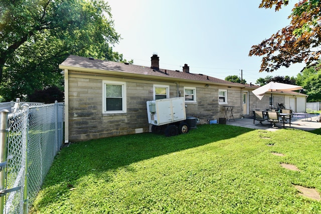 4020 S Lynhurst Dr, Indianapolis, IN 46221 - back of property with stone siding, a chimney, a patio area, a fenced backyard, and roof with shingles