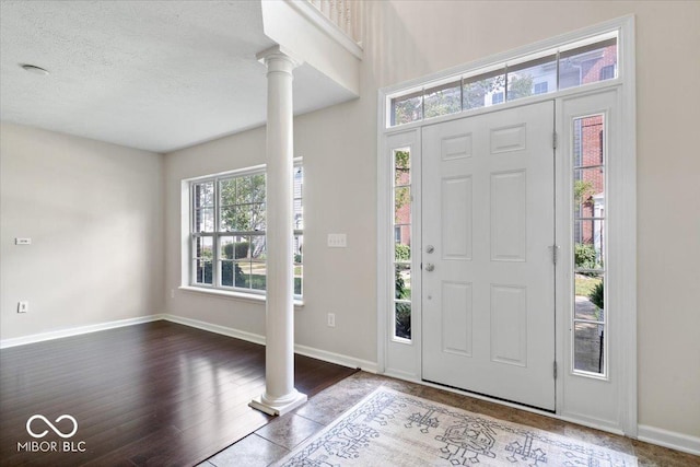 8256 Jo Ellen Dr, Fishers, IN 46038 - foyer with ornate columns, dark wood-style flooring, and a textured ceiling